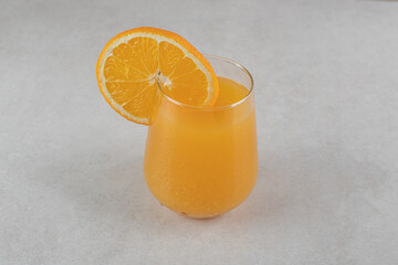 A glass of orange juice on gray background