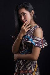Beautiful young asian woman wearing batik isolated on black background. Batik Day.