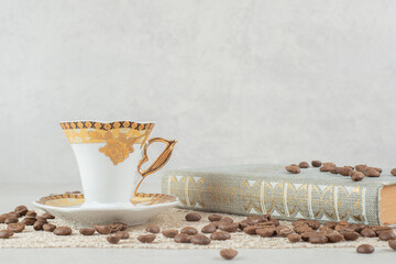 Cup of espresso, book and beans on marble background