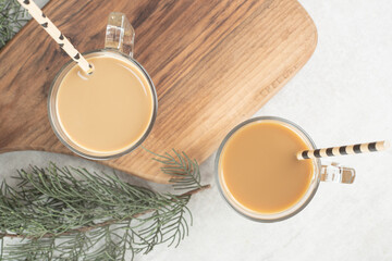 Two glasses of coffee with straws on wooden board