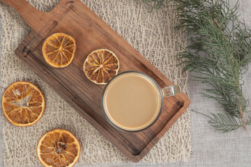 Obraz na płótnie Canvas Glass of coffee on wooden board with orange slices