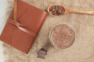 Coffee, coffee beans and notebook on burlap