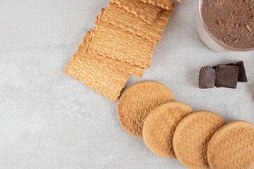 Glass of coffee and various biscuits on marble surface