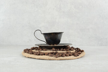 Coffee beans and cup of coffee on wood piece