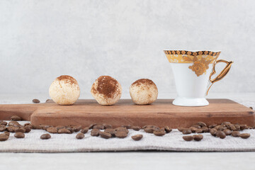 Espresso and cookies on wooden board with coffee beans
