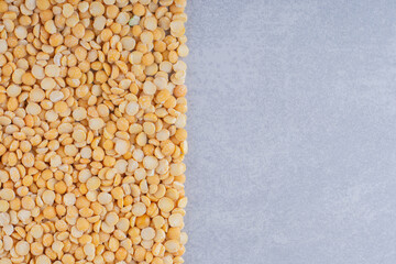 Pile of lentil grains neatly laid out on marble background