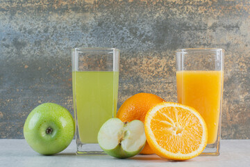 A green and orange drinks on marble background
