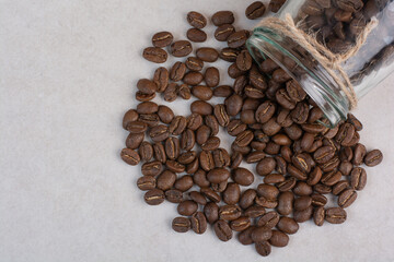 A glass jar of coffee beans on white background
