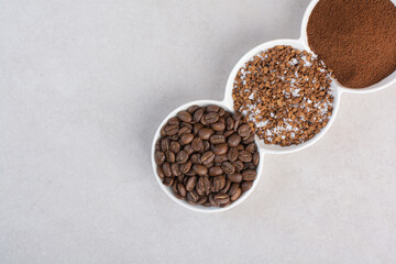 A three white plate full of coffee beans and cacao powder