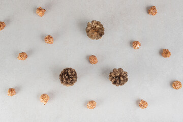Pine cones and bits of candied popcorn all over the marble background