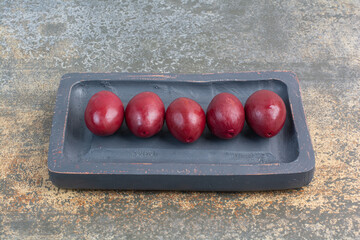 Delicious sweet fruits in dark board on marble background