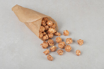 A serving of popcorn candy in a paper wrapping on marble background