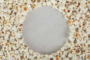 Mass of popcorn with an empty circular space in the middle, on marble background
