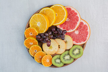 Various fruit slices on wooden plate