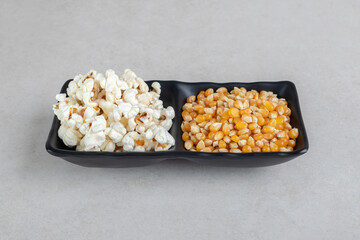 Two-sided serving platter with corn kernels and popcorn on marble background