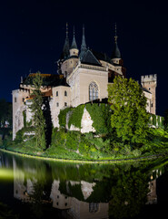 Fototapeta na wymiar view of the Bojnice Castle with reflections in the water at night
