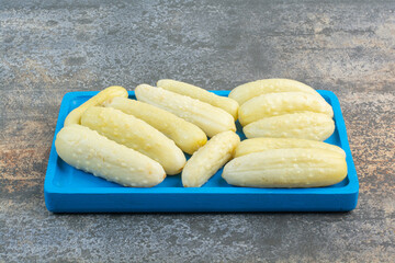 Salty delicious cucumbers on blue plate