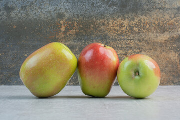 Three fresh apples on stone background