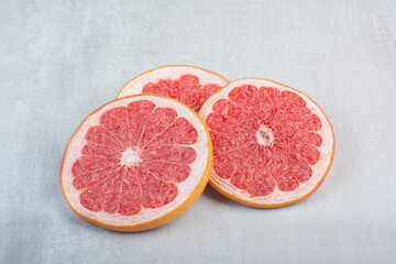 Juicy grapefruit slices on stone background