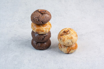 Stack of various cookies with walnut on beige background