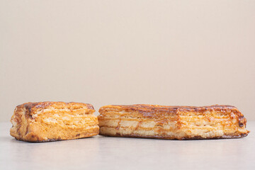 Delicious creamy eclairs on beige background