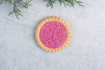 Tasty cookie with sprinklers on gray background