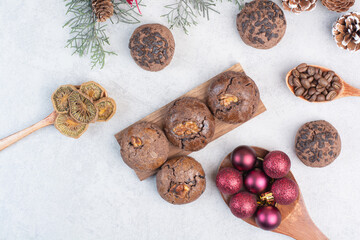 Chocolate cookies, baubles and dried fruits on gray background