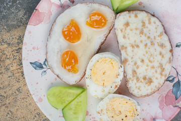 Breakfast plate with bread and eggs on marble surface