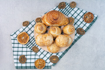 Variety of sweet biscuits on wooden piece with dried fruits