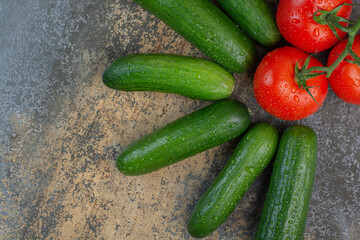 Fresh tomatoes and cucumbers on marble background