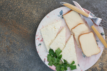 Various cheese slices on plate with cutlery