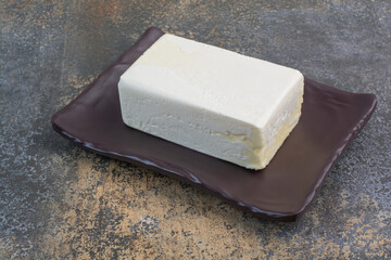 Organic white cheese on dark plate