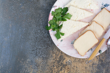 Various cheese slices on plate with cutlery