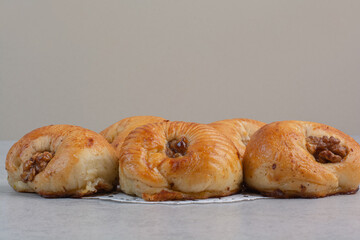 Sweet biscuits with walnut kernels on gray background