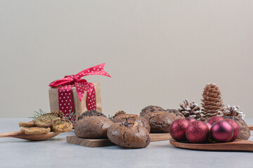 Chocolate cookies with gift box, baubles and pinecones