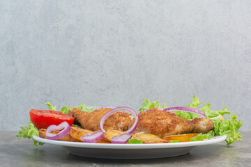 Chicken nuggets with fried potato and onion on white plate
