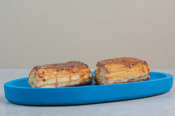 Two fresh delicious pastry on blue plate