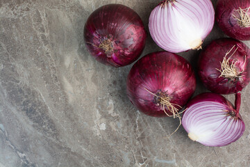 A lot of red onion bulbs on marble background