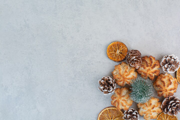 A lot of fresh delicious cookies with small pinecones and dried oranges