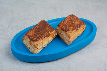Two fresh delicious pastry on blue plate