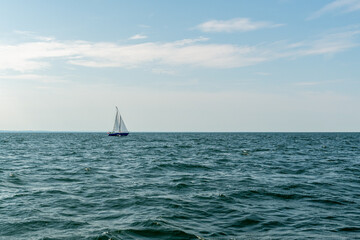 mały jacht żaglowy na spokojnych wodach zatoki Morza Bałtyckiego - obrazy, fototapety, plakaty