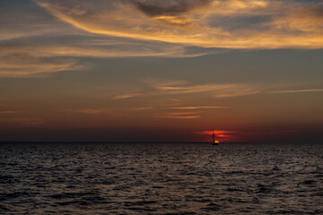 samotny jacht na morzu w czasie zachodu słońca