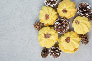 A lot of fresh delicious cookies with small pinecones on white background