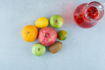 Jar of juice and fresh vegetables on blue background