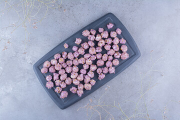 Small tray with bundle of popcorn candy on marble background