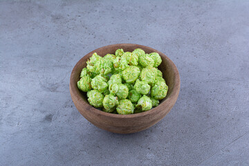 A small bowl of candied popcorn on marble background