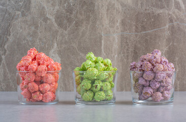 Small servings of assorted popcorn candy on marble background