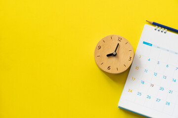 close up of calendar and clock on the yellow table background, planning for business meeting or travel planning concept