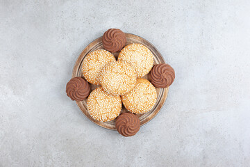 Decorative stack of homemade cookies on wooden tray, on marble background