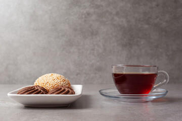 A plate of cookies and a cup of fragrant tea on marble background